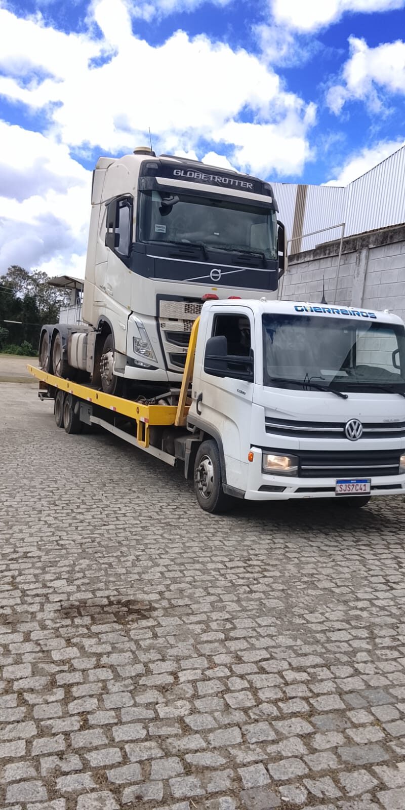 Prancha transportando cavalo mecânico Volvo no pátio