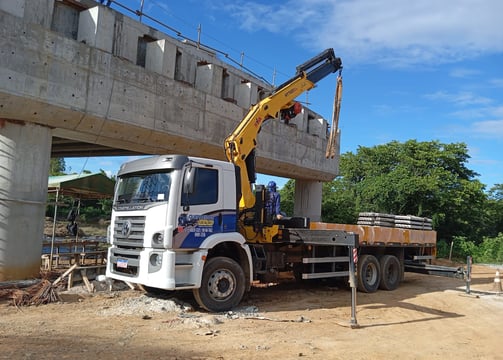 Caminhão munck Guerreiros Guinchos içando carga em obra